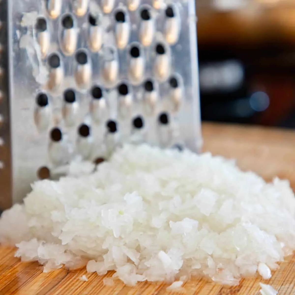 Geriebene Zwiebeln auf einem Holzbrett.