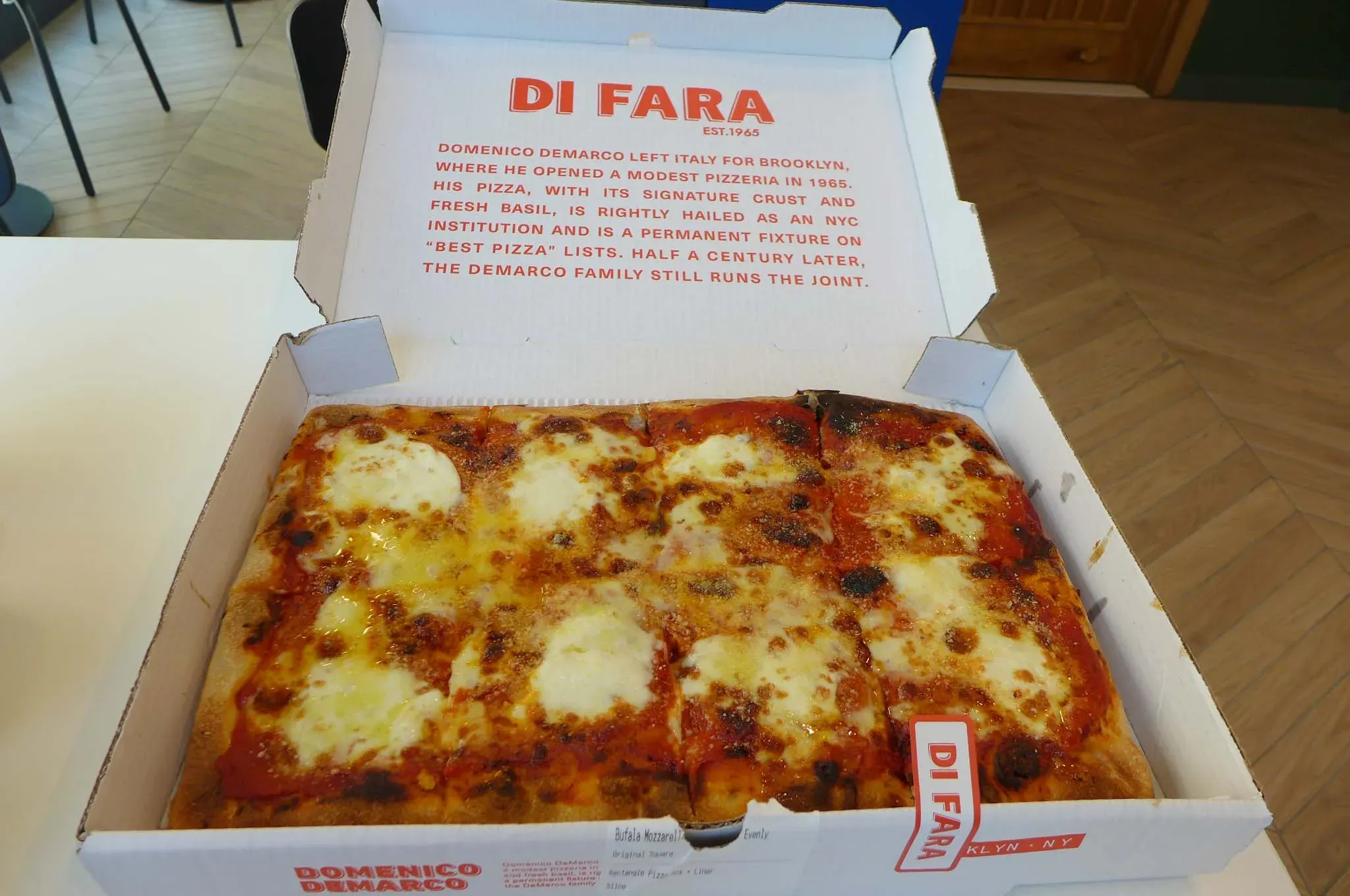 Rechteckige Pizza in offener Box.