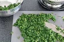 Abgetropfter und ausgedrückter TK-Blattspinat, grob gehackt in einer Schüssel.