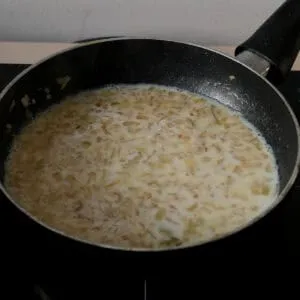 adding milk to the onions and warming it up.