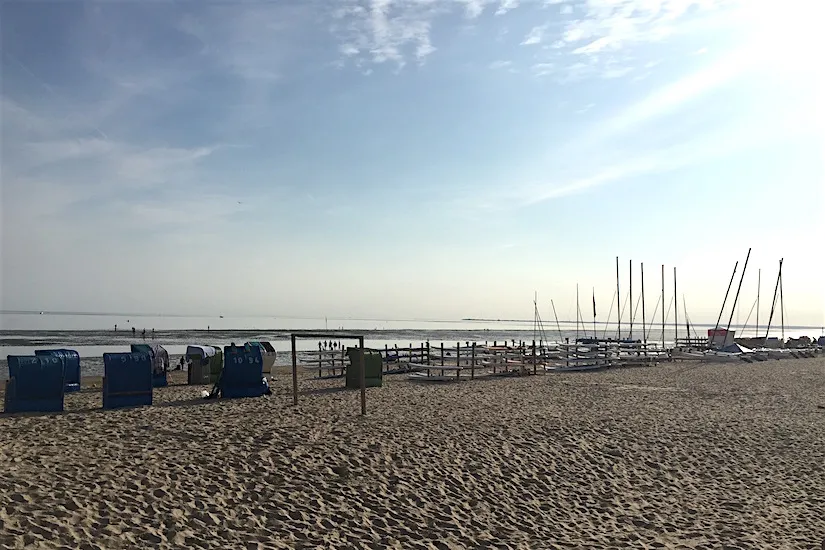 Aktivurlauber beim Kitesurfen an einem weiten Sandstrand auf Föhr, Nordsee
