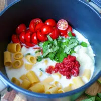 Alle frischen Zutaten für die One-Pot-Pasta wie Nudeln, Kirschtomaten und Kräuter werden zusammen in einem Topf gekocht.