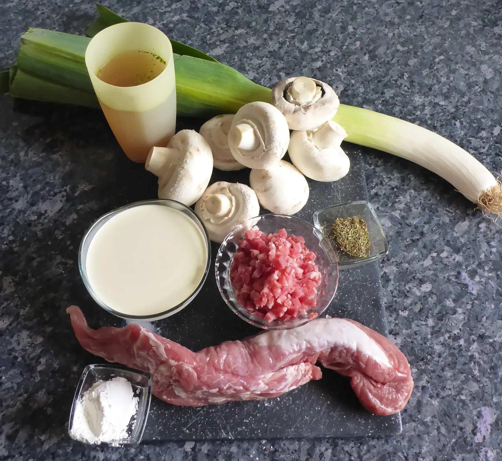 Alle frischen Zutaten für die Schnitzelpfanne bereitgelegt: Schweinefilet, Pilze, Lauch, Speck, Sahne