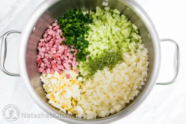 Alle gewürfelten Zutaten wie Schinken, Gurken, Eier, Dill und Lauchzwiebeln in einem großen Topf vermischt.