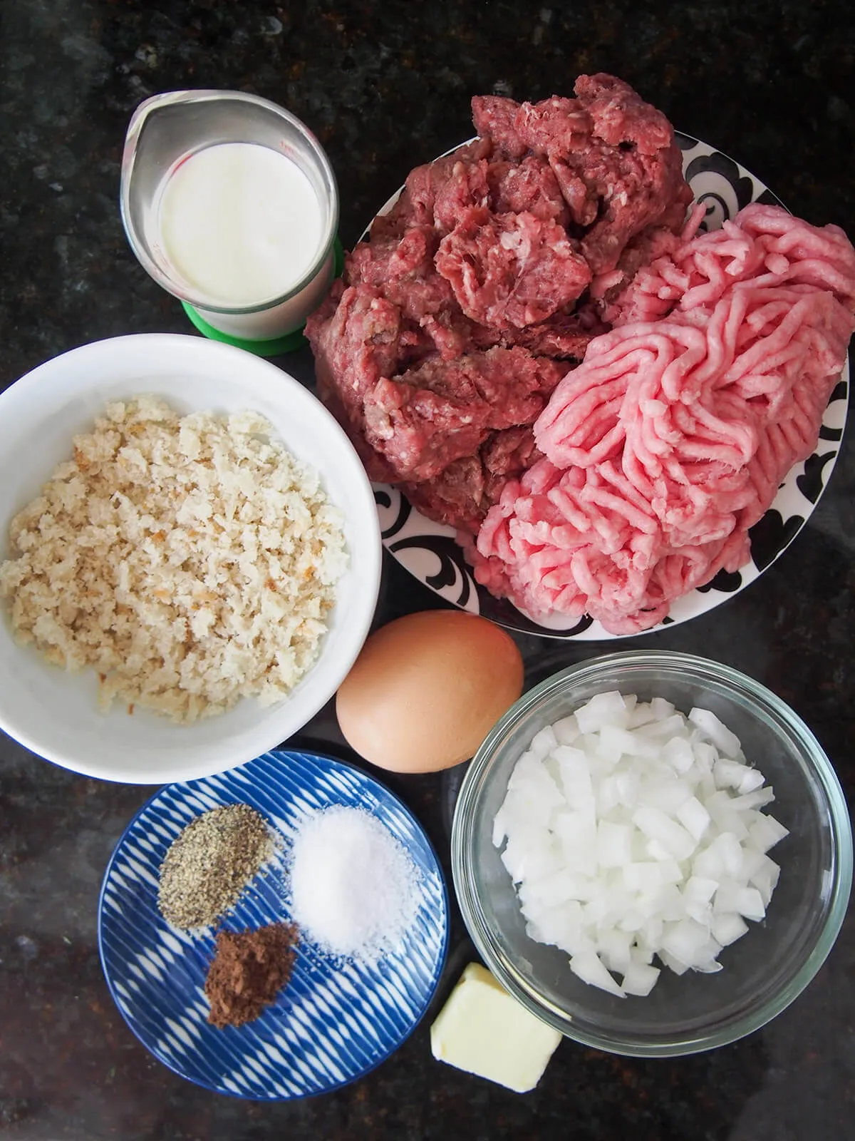 Alle Zutaten für Köttbullar bereitgestellt: Hackfleisch, Paniermehl, Zwiebel, Ei, Sahne und Gewürze