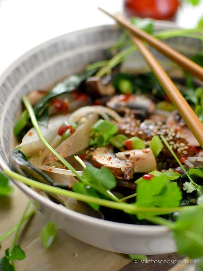 Als Topping dienen Koriander, scharfe Sauce und Sesam bei der asiatischen Nudelsuppe