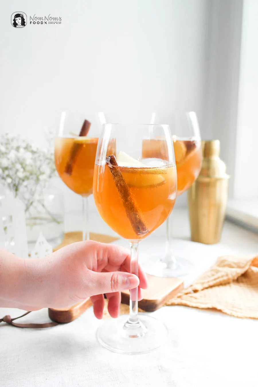 Amaretto Spritz mit Apfelsaft, Ginger Ale und Sekt im Glas mit Apfelspalte