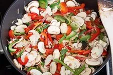 Anbraten von Gemüse und Speck in der Pfanne für die Soße