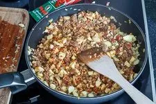 Anbraten von Rinderhackfleisch mit Gewürzen und Zucchini-Fruchtfleisch in der Pfanne für eine aromatische Füllung