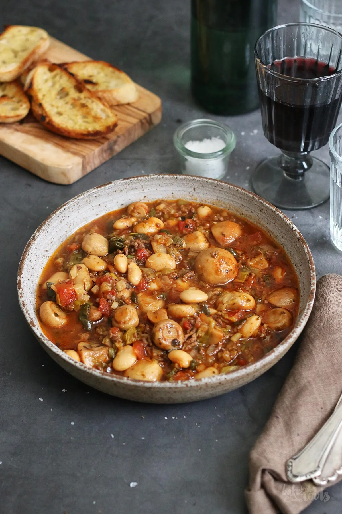 Angebratene Champignons in einem gusseisernen Topf, ein wichtiger Schritt für den Schmortopf