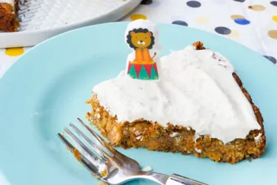 Angeschnittener Möhren-Apfel-Kuchen mit Frischkäse-Glasur auf einem Teller