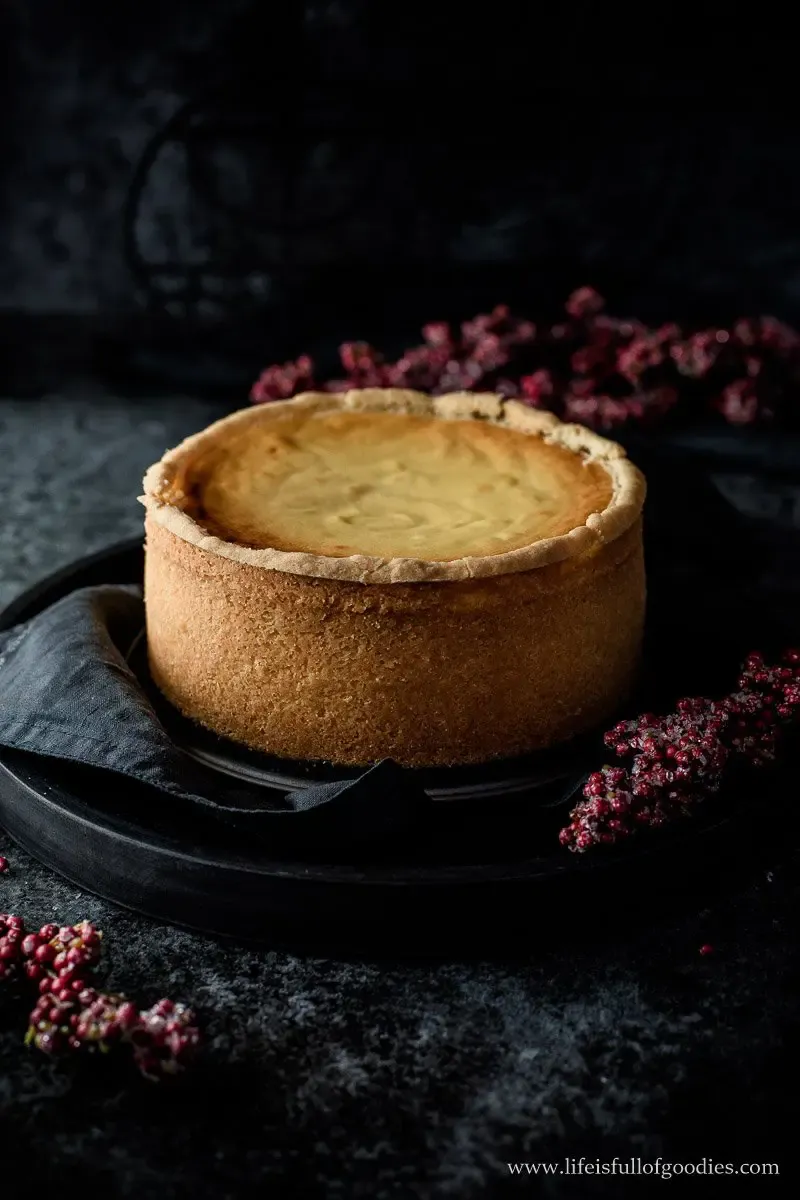 Anschnitt eines hohen Käsekuchens mit cremig-weißer Füllung und knusprigem Boden