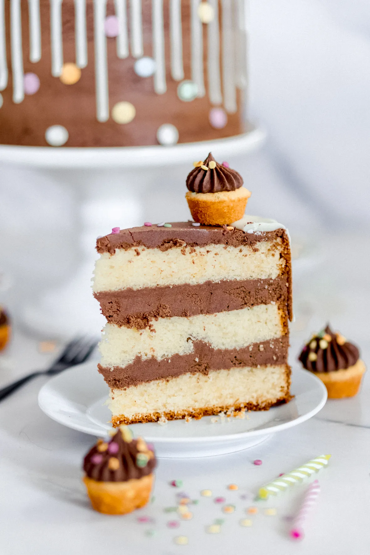 Ansicht einer fertig dekorierten Sahnetorte mit Mini-Muffins und Kerzen