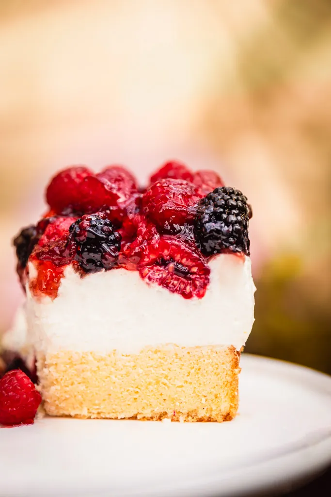 Ansicht eines Stücks Mascarpone Joghurt Sahne Torte mit luftiger Creme und Beerentopping