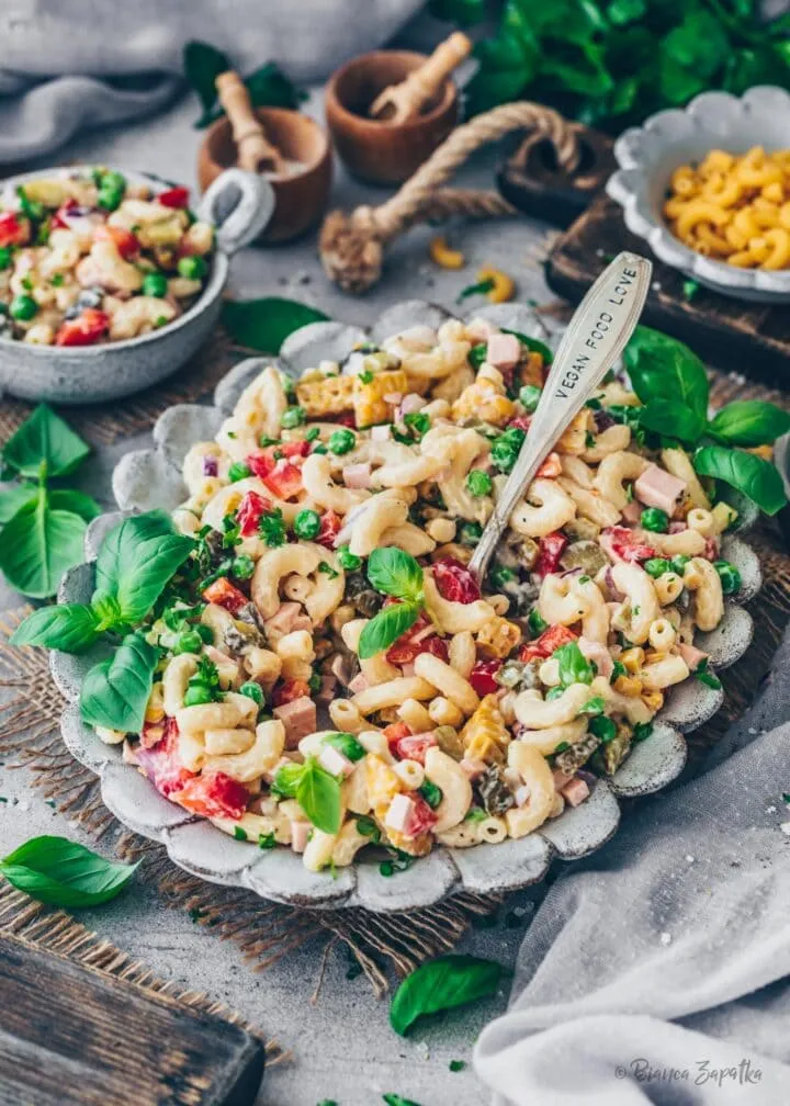 Ansicht eines veganen Nudelsalats mit veganer Fleischwurst, Gurken, Erbsen, Mais, Zwiebeln und Paprika.