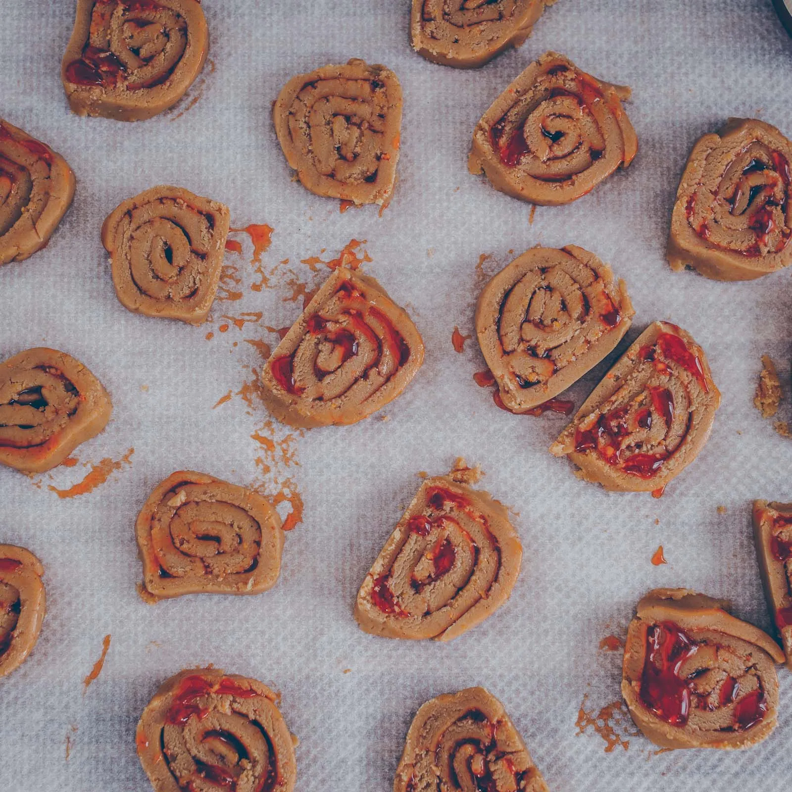 Ansprechende Präsentation mehrerer fertiger Konfitüre-Rollen mit Hagebutten-Konfi, die goldbraun gebacken sind
