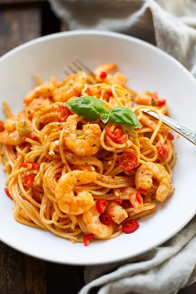 Ansprechende Präsentation von Spaghetti mit Garnelen und Tomaten-Sahnesauce auf einem Teller, bereit zum Genießen als schnelles Abendessen