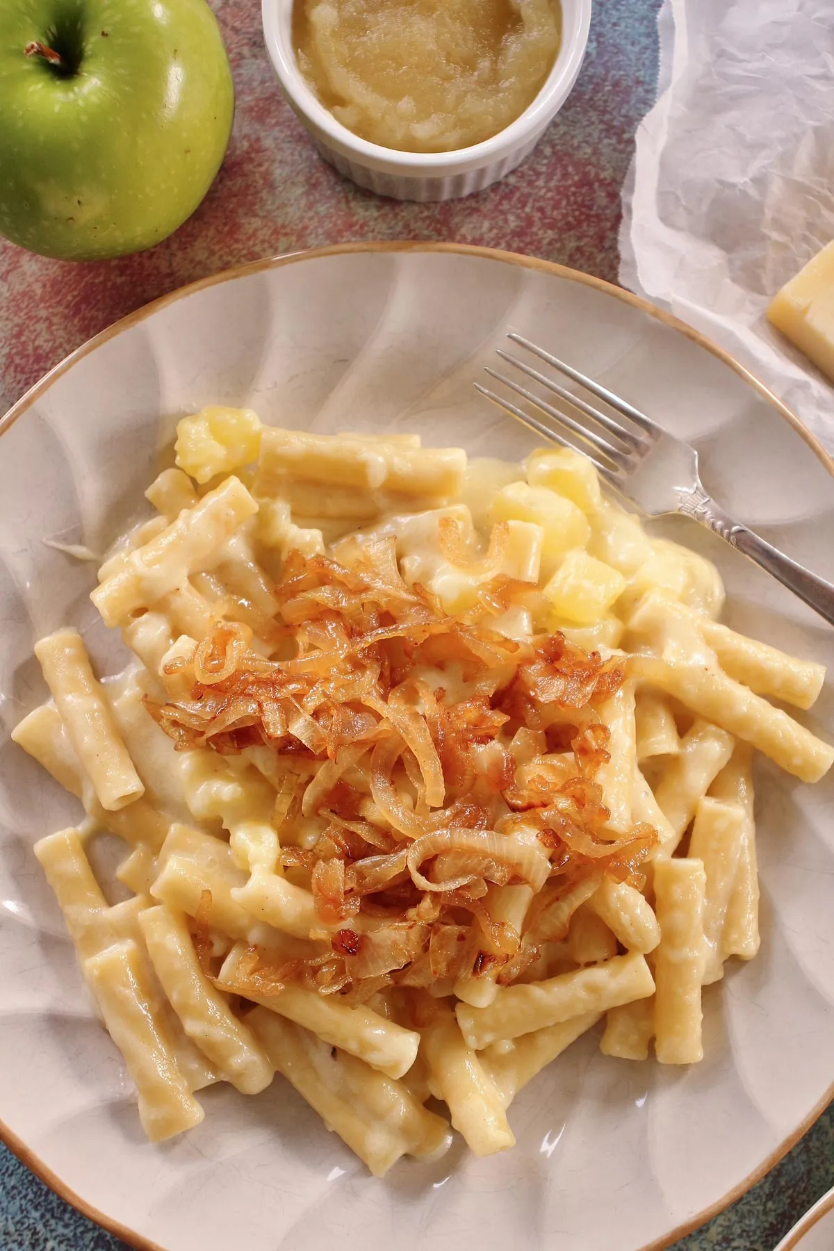 Ansprechender Teller Schweizer Käsemakkaroni, reichlich garniert mit goldbraunen karamellisierten Zwiebeln