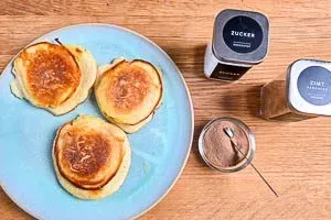 Apfelküchlein servieren: Mit Zimt und Zucker verfeinern