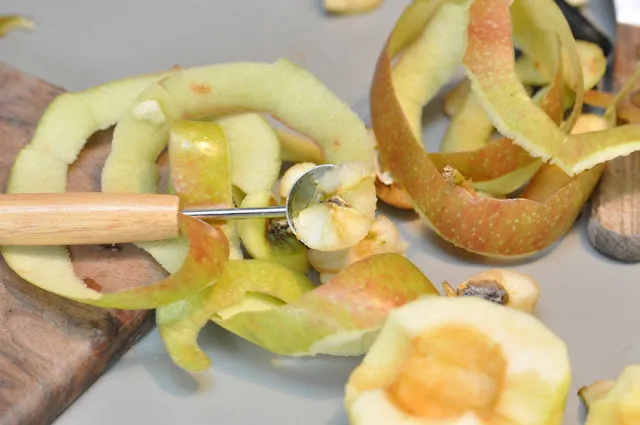 Apfelscheiben werden überlappend in konzentrischen Rechtecken auf einem Teig verteilt.