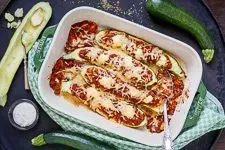 Appetitliche gefüllte Zucchini Schiffchen mit geschmolzenem Käse, direkt aus dem Ofen und bereit zum Genießen