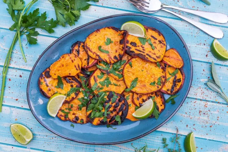 Appetitliche gegrillte Süßkartoffelscheiben, verfeinert mit Limette und Olivenöl, bereit zum Servieren als gesunde Beilage.