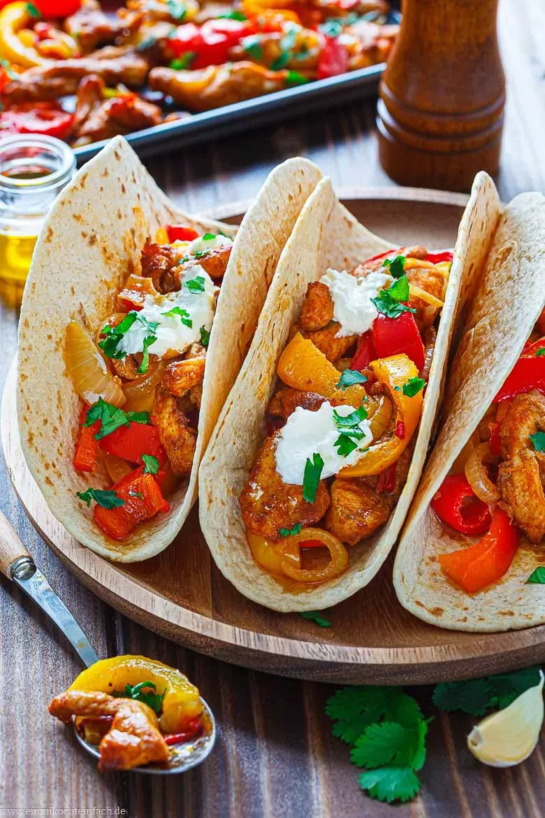Appetitliche Hähnchen Fajitas in einer Pfanne angerichtet, bereit zum Befüllen von Tortillas mit frischem Koriander