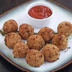 Arancini auf einem weißen Teller mit Soße auf der Seite - Feature Image