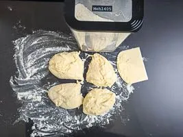 Arbeitsplatte bestäuben und Teig vierteln