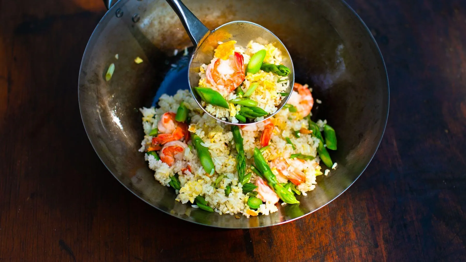 Aromatischer gebratener Reis mit Garnelen, grünem Spargel und Ei, ein schnelles chinesisches Reisgericht aus dem Wok