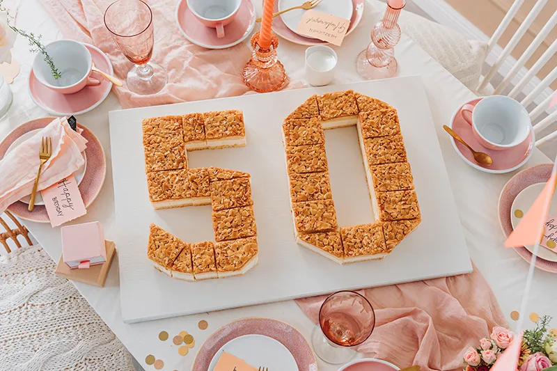 Arrangement der Kuchenstücke zu der Zahl 50 auf einem Servierbrett