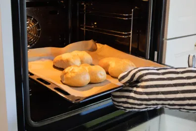 Auf einem Blech im Backofen aufgebackene Brötchen