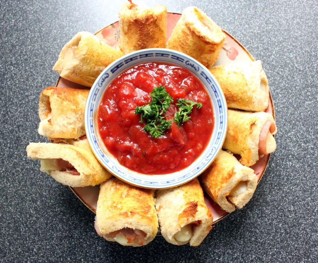 Aufgeschnittene Käserolle mit geschmolzenem Käse und Schinkenfüllung, bereit zum Genießen