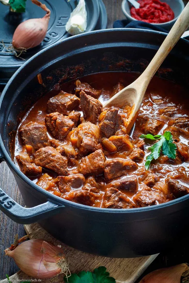 Auswahl an frischen Zutaten wie Schalotten, Knoblauch und Zitrone für ein authentisches Gulasch