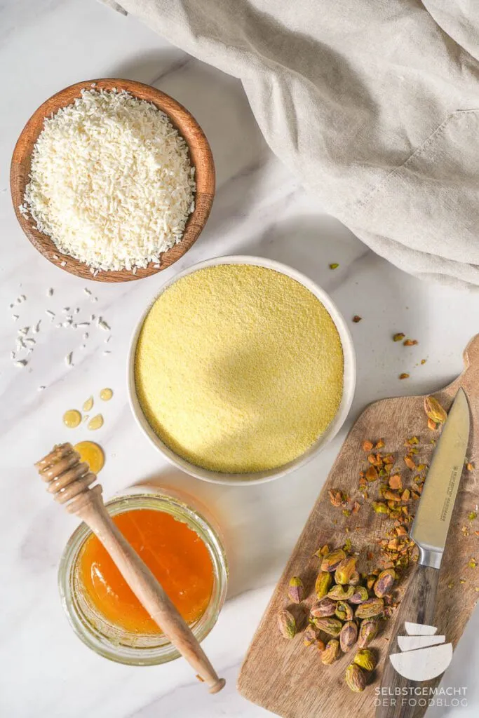 Auswahl an Zutaten für einen türkischen Grießkuchen Revani auf einem Holztisch