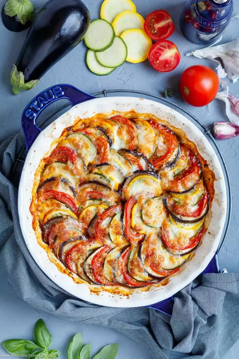Auswahl frischer Sommergemüse: Zucchini, Auberginen, Tomaten und Mozzarella, bereit für die Zubereitung des Ofenrezepts.