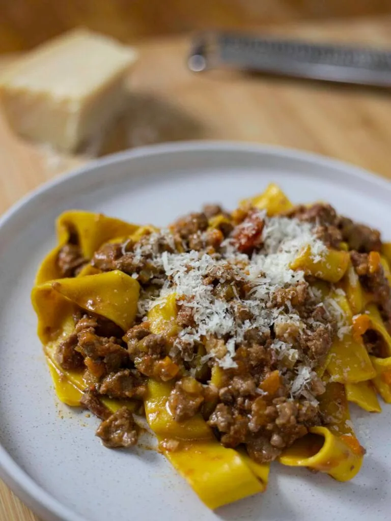 Authentic parpardelle alla bolognese with grated parmesan