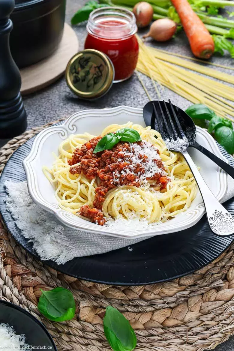 Authentische Bolognese Soße mit frischen Kräutern auf Bandnudeln angerichtet