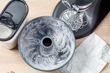 Backschritt 1: Eine vorbereitete Gugelhupf-Form, gefettet und mit Mehl bestäubt, bereit für den Teig.