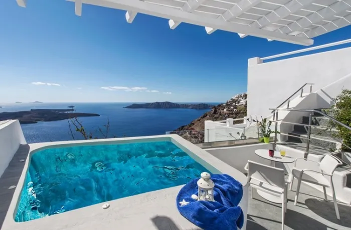 Badeurlaub 2025 – zum Beispiel in diesem inseltypischen Erwachsenenhotel mit eigenem, kleinen Pool auf der Terrasse, regionaltypisch weißgetünchte Wände, viel Ausblick auf die blaue Caldera