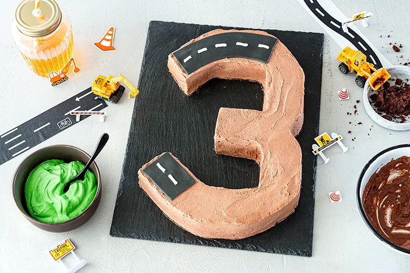 Bagger Geburtstagstorte mit Schokocreme bestreichen und Fondantstraße anlegen