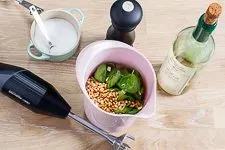 Basilikum, Öl und Pinienkerne mit Pürierstab zerkleinern