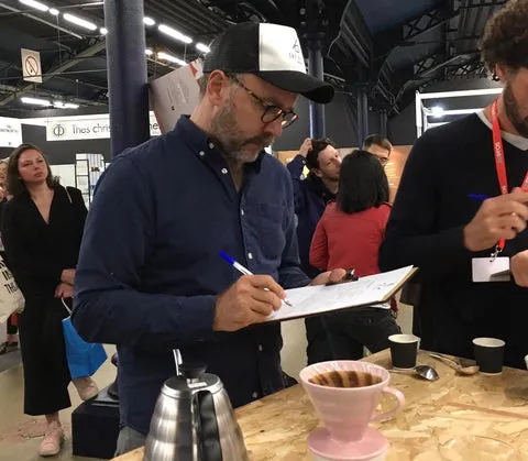 Besucher genießen Spezialitätenkaffee auf einem internationalen Kaffeefestival, das die deutsche Kaffeekultur widerspiegelt.