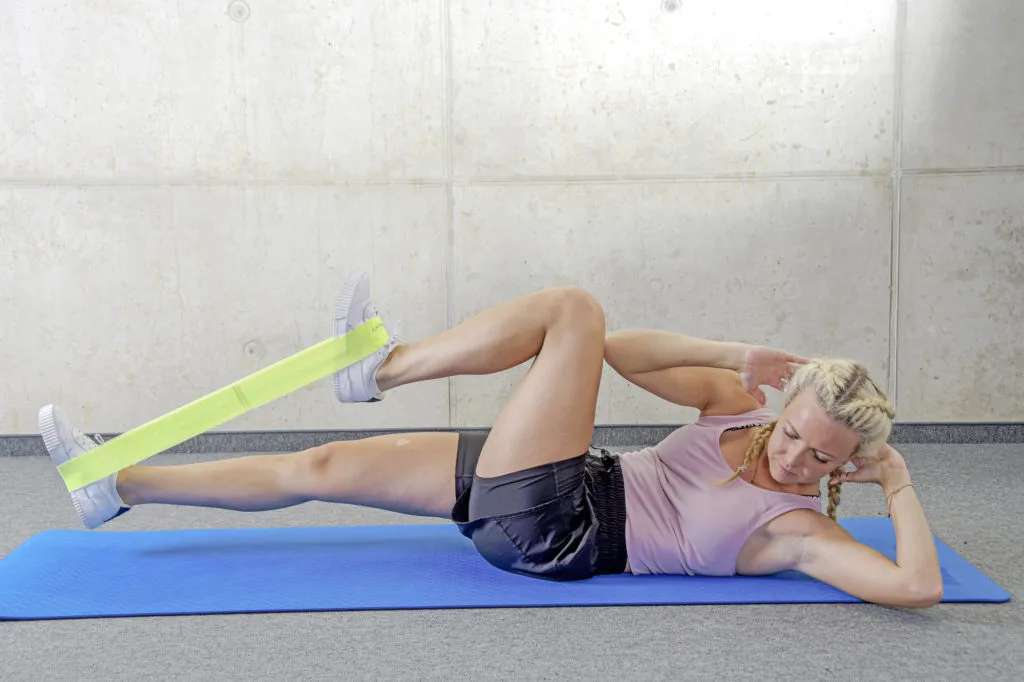 Bicycle-Crunch mit Miniband zwischen den Füßen für ein effektives Bauchmuskeltraining im Tennis