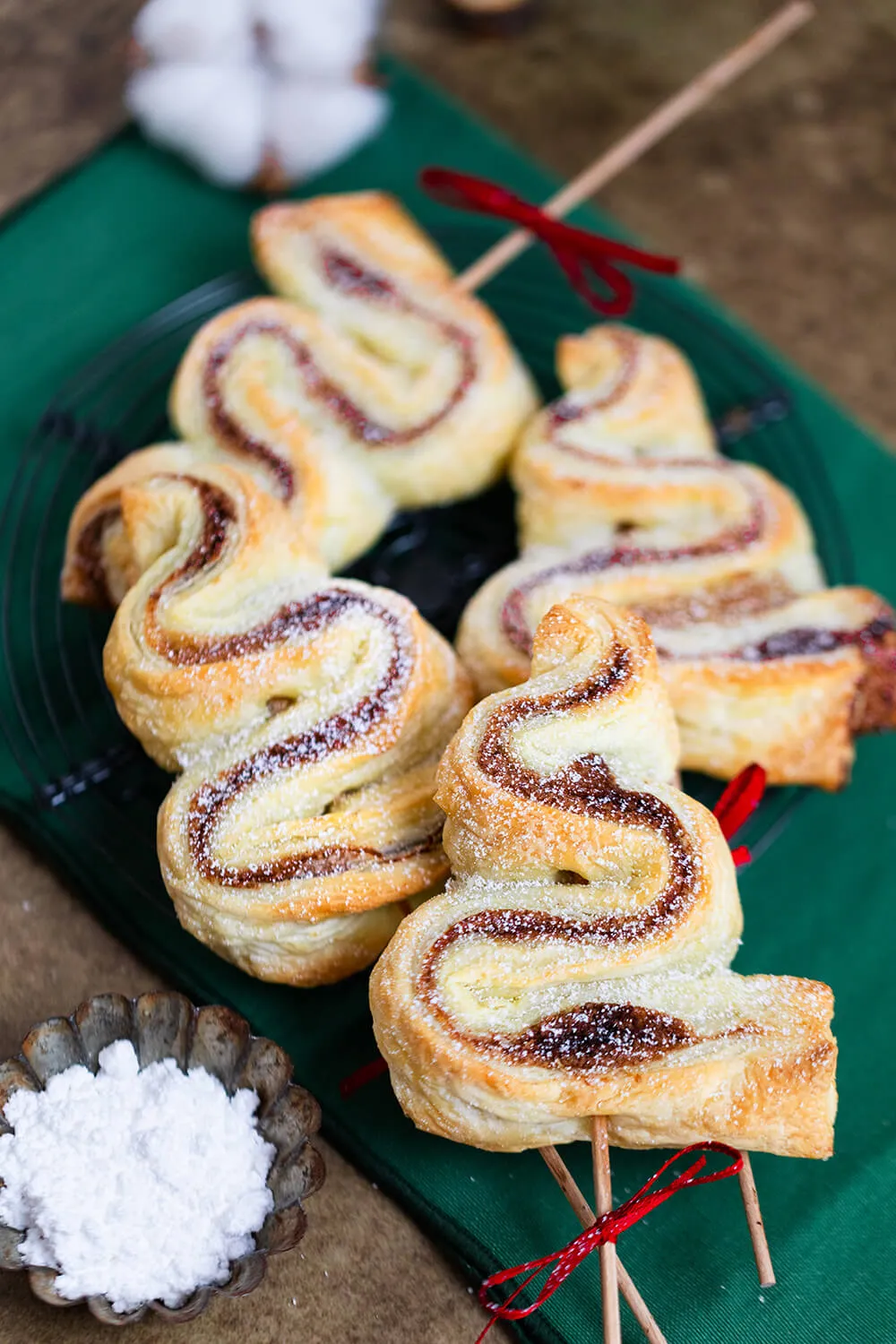 Blätterteig-Tannenbäume als süßer Snack für Weihnachten mit Puderzucker bestreut