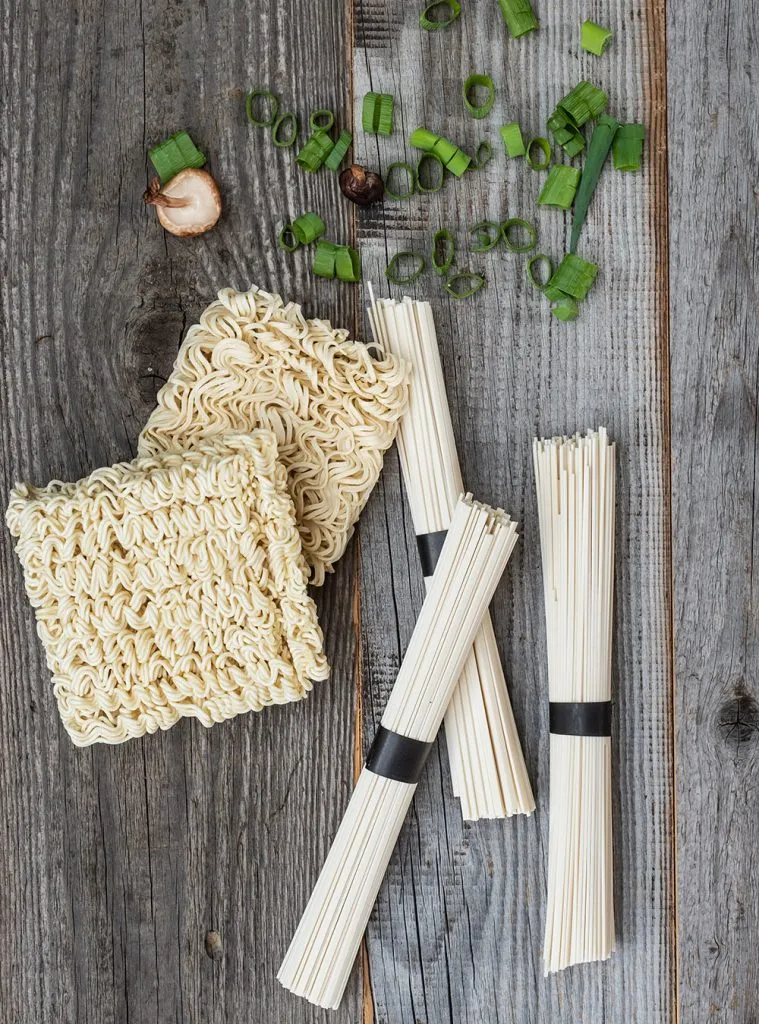 Blick in eine dampfende Ramen Schüssel mit Nudeln und verschiedenen Toppings