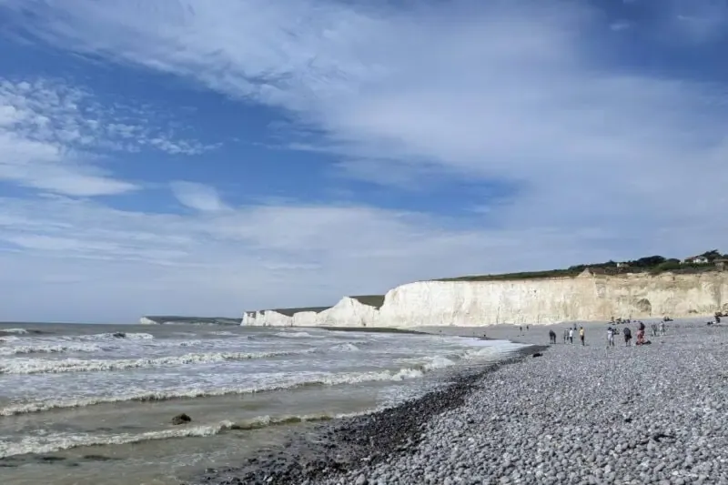 Blick über den Kiesstrand und die weitläufigen weißen Klippen der Seven Sisters