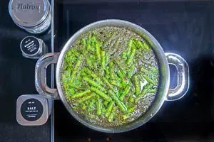 Bohnen mit Salz, Bohnenkraut und Natron kochen lassen.