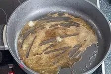 Bratensatz wird mit Rinderfond abgelöscht, um eine geschmackvolle Soße für das Rinderfilet-Gericht zu kreieren.