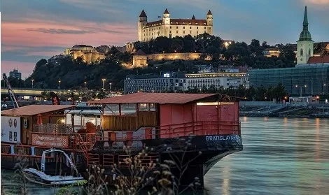 Bratislava bei Nacht mit der beleuchteten Burg und der Donau, ein charmantes Städtereiseziel für Studierende